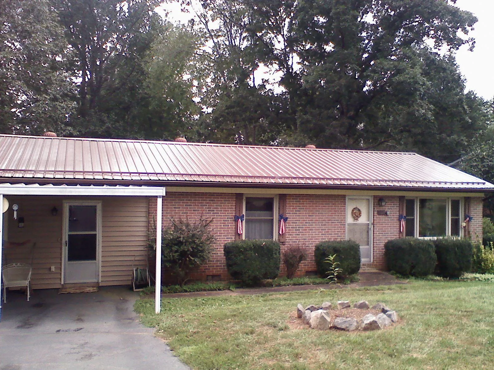 Bronze metal roof and carport on a brick ranch home — Roof Repair work by our crew in Red Oak